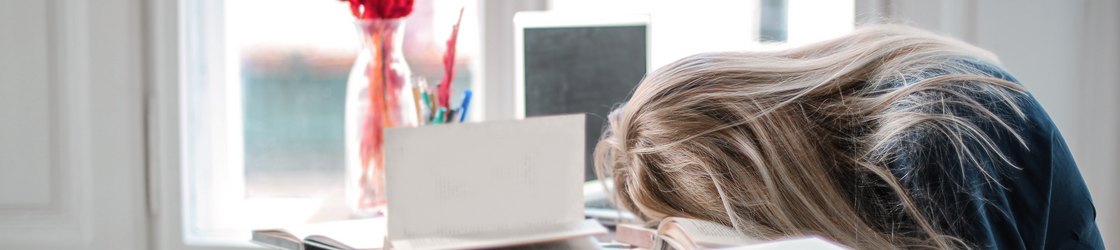 un esempio di bisogno di integratori nutraceutici: persona stanca con testa appoggiata sulla scrivania